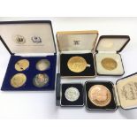 Five cased commemorative coins.