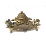 A small ormolu inkwell having porcelain well and a small metal figure of a cherub, approx 15cm