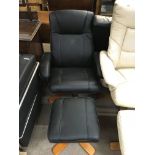 A modern black leather upholstered swivel armchair and Matching foot stool.