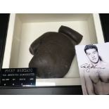 A framed boxing glove with applied plaque attributed to Rocky Marciano fitted in a case .