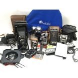 A box containing a collection of cameras and photographic accessories including a Kodak TLR, Kodak