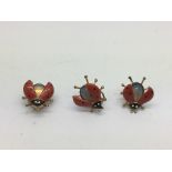 Three enamel ladybird clip brooches.