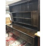 An interesting early 19th century oak dresser with Mahogany cross banding the plate rack with two