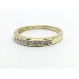 An 18ct yellow gold half eternity ring, having a row of nine princess cut diamonds, approx 0.25ct,