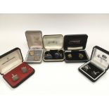 Five boxed pairs of cufflinks.