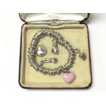 A silver Links of London bracelet with five charms, consisting of two hearts a dog, a rabbit and a