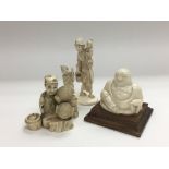 Three early 20th Century carved ivory figures comprising a buddha, mother and children plus one