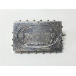 A silver brooch depicting a scene of Dunster Castle in Somerset, with impressed mark S.BROS