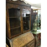 A walnut bureau bookcase with a pair of glazed doors Fall front above five drawers on cabriole