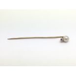 A stick pin set with a natural pearl and a diamond