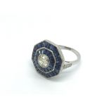 A platinum octagonal sapphire and diamond ring set with a central old cut diamond, approx 0.65ct,