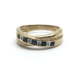 A 9ct yellow gold crossover ring having a row of alternating sapphires and diamonds, ring size