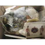 A box containing military items cloth badges buttons shell cases retrospective ephemera and other