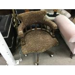 An upholstered swivel captains/desk chair