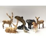 A collection of seven Beswick animals including three deer, a fish, a camel, a bird and an elephant