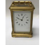 A brass case carriage clock the enamel dial with Roman numerals striking on a gong . With key .