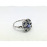 A Victorian style platinum sapphire and diamond panel ring set with a central oval cut sapphire, RBC