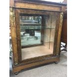 A Victorian walnut pier cabinet inlaid with gilt metal mounts the single door enclosing glass