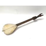 A carved native single string musical instrument with skin soundbox