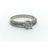 An 18ct white gold and diamond solitaire ring, the single central approx 0.33ct diamond flanked by