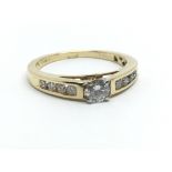 An 18ct yellow gold ring, the central diamond solitaire flanked by eight smaller diamond, approx 0.