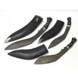 Three Gurkha Kukri knives in black sheaths with decorated handles