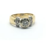 An 18ct yellow gold and diamond ring, the central diamond flanked by six smaller diamonds, ring size