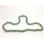 A vintage jade bead necklace with a silver clasp.