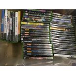 A box containing a collection of Xbox games and cheat books