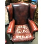 An Oxblood leather wingback armchair plus an addit
