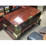 An Oriental red painted and brass bound chest with