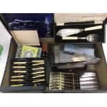 A suitcase of mixed cased cutlery.