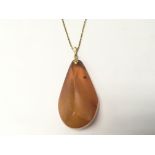 A large amber pendent with attached gold chain mar
