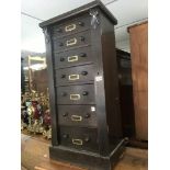 A black stained wooden 7 drawer wellington chest.