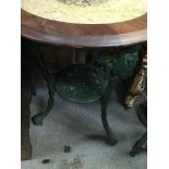 A cast iron pub table with wooden circular top