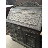 A 19th century carved oak bureau with a fall front