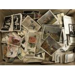 A box of various loose cigarette cards, including