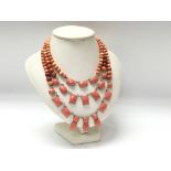 A three strand necklace featuring coral coloured s