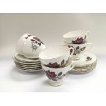 A decorative tea with decorated with roses on a wh