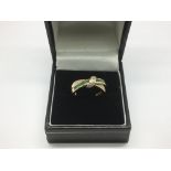 A 9ct gold emerald and diamond crossover ring, app