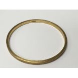 A 9carat gold bangle with engine turned decoration