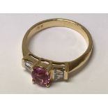 An 18ct yellow pink sapphire and diamond ring. Ova
