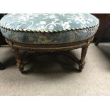 A large oval gilt framed stool The floral upholste
