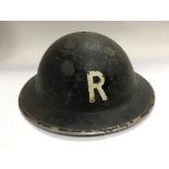 A WW2 era tin hat marked R to the front.