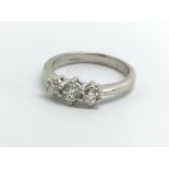 A 9ct white gold ring set with three diamonds, app