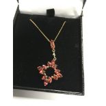 A 9 ct gold pendant set with red stones single dia