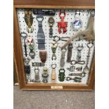 A framed collection of bottle openers.