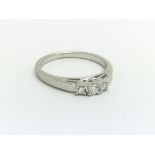 A 14ct white gold and three stone diamond ring, ap