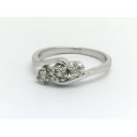 A 9ct white gold and three stone diamond ring, app