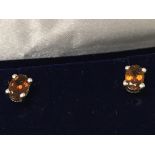 A pair of oval cut brown tourmaline studs, set in
